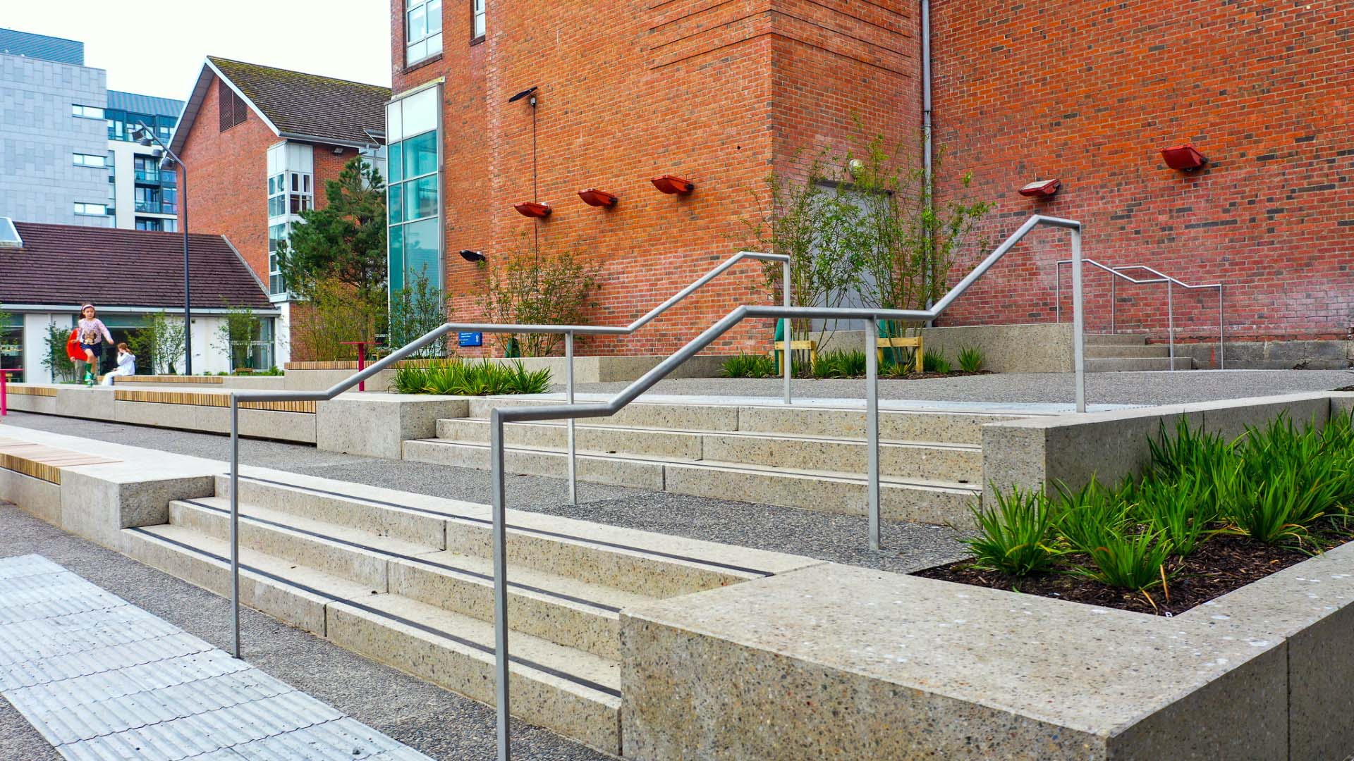 Accessible steps and ramp with handrails beside red brick buildings in South Dublin County