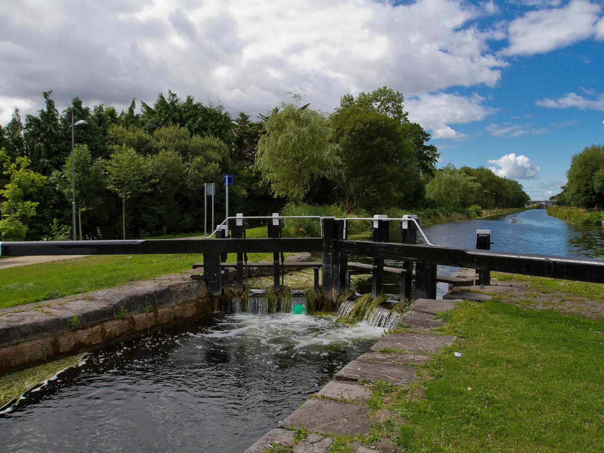 Canal lock on the Grand Canal in Clondalkin with flowing water and towpath
