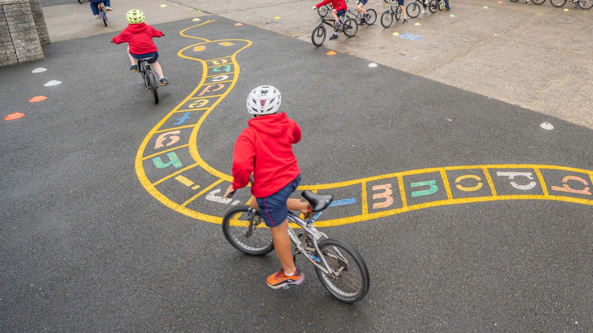 Primary school children cycling through a skills course during a Safe Cycle Programme session