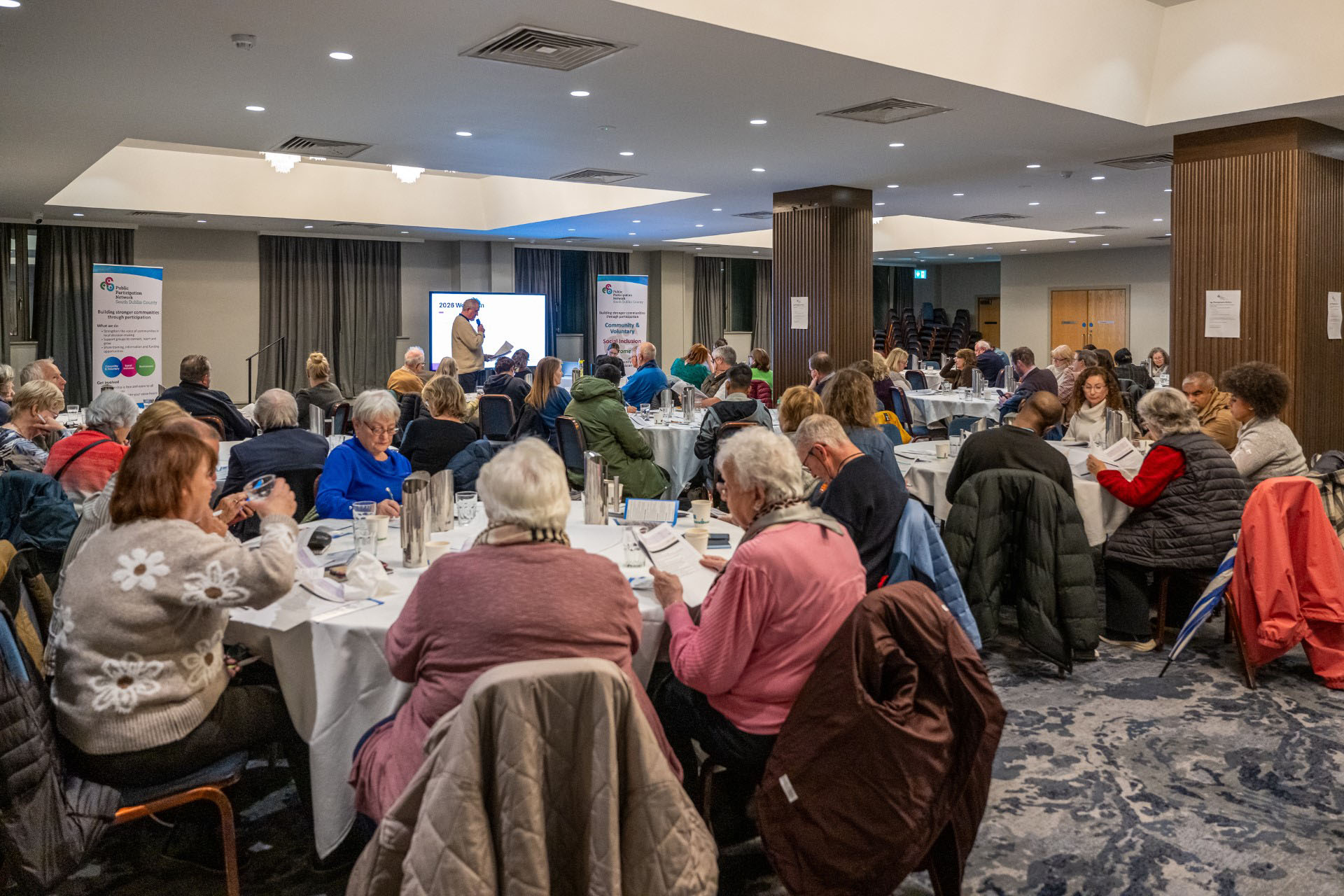 Wide view of participants seated at round tables during PPN Plenary, Plaza Hotel, Tallaght